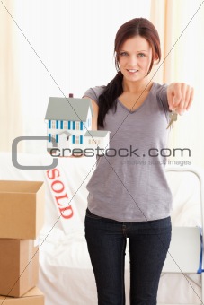 Portrait of a woman with model house and keys