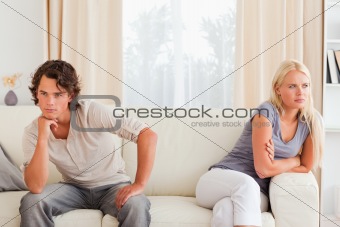 Sorrowful couple sitting on a couch 