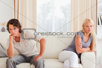 Sorrowful couple sitting on a sofa