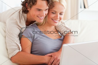Lovely young couple using a laptop
