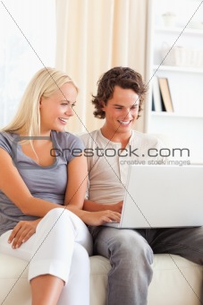 Portrait of a cute happy couple using a notebook
