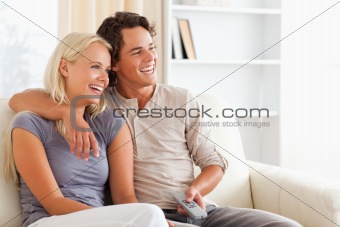 Laughing couple watching TV