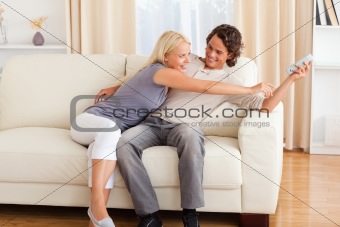 Smiling couple fighting for the remote