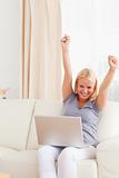 Woman cheering up while using a laptop