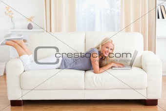 Woman lying on a sofa with a notebook