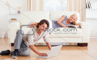 Man with a notebook while his girlfriend is holding a book