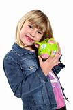 Little girl holding a green piggy bank