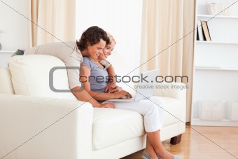 Smiling young couple using a notebook