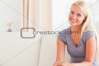 Blonde woman sitting on her sofa