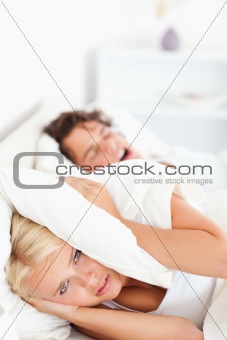 Portrait of an unhappy woman awaken by her fiance's snoring