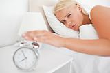 Tired woman awaken by an alarmclock