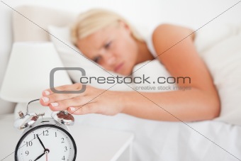 Woman switching off her alarm clock