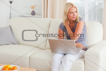 Woman having a shoulder ache while using her laptop