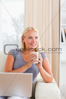 Portrait of a woman having a tea while holding a notebook