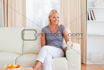 Woman sitting on a sofa with a cup of tea