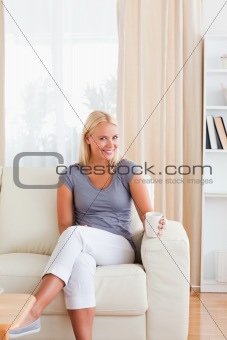 Portrait of a woman sitting on a sofa with a cup of tea