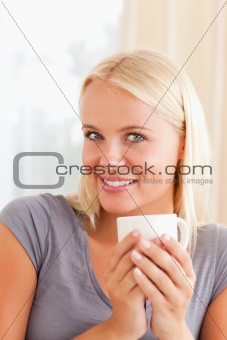 Portrait of a woman sitting on a couch with a cup of coffee