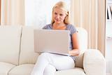 Woman sitting on a sofa while using a laptop