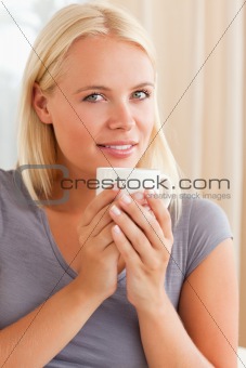 Portrait of a calm woman sitting on a couch with a cup of tea