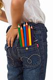 Child with color pencils in back pocket
