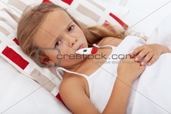 Sick kid in bed holding thermometer between lips