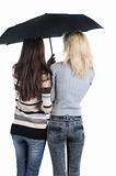 Two women under an umbrella. Rear view. 