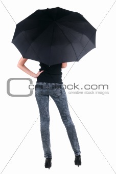 Blond young woman under an umbrella. Rear view.
