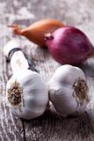 closeup of garlic and onions on a wooden board