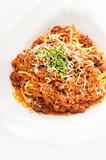 spaghetti with bolognese sauce and fresh vegetables on background