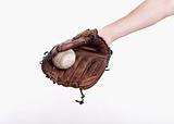 hand holding a baseball glove with the ball in it - isolated on white