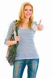 Happy pretty girl with backpack showing thumbs up gesture
