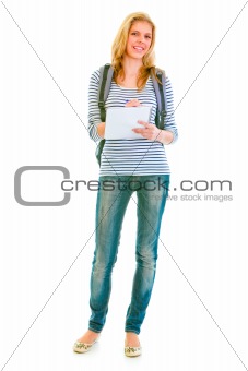 Full length portrait of smiling teen girl with schoolbag writing in notebook
