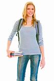 Cheerful teen girl with schoolbag holding books in hand
