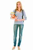 Full length portrait of smiling pretty teen with backpack and schoolbooks
