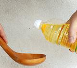 Pouring oil into wooden spoon