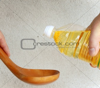 Pouring oil into wooden spoon