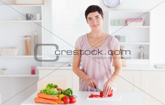 Smiling woman slicing vegetables
