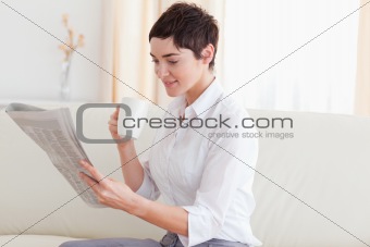 Woman with a cup reading the news