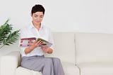 Beautiful brunette woman reading a magazine