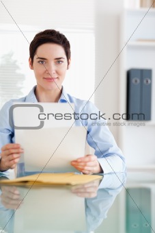 Portrait of a Businesswoman sitting behind a desk with papers
