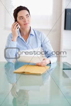Businesswoman with papers on the phone
