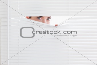 Brunette businesswoman peeking out of a window