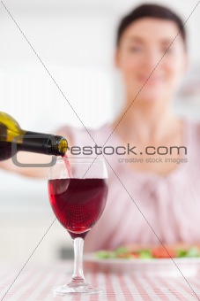  Brunette Woman pouring redwine in a glass