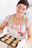 Happy brunette woman showing muffins
