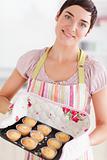 Brunette woman showing muffins