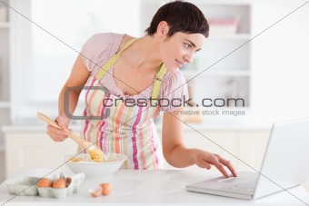 Woman looking at a receipt on a laptop
