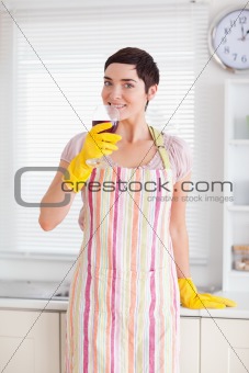 Smiling woman in cleaning gown with wine