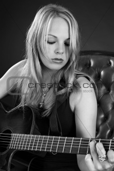 Attractive blond female playing guitar