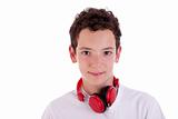 young man standing listening to music on red headphones, isolated on white, studio shot