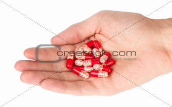 human hand holding red pills